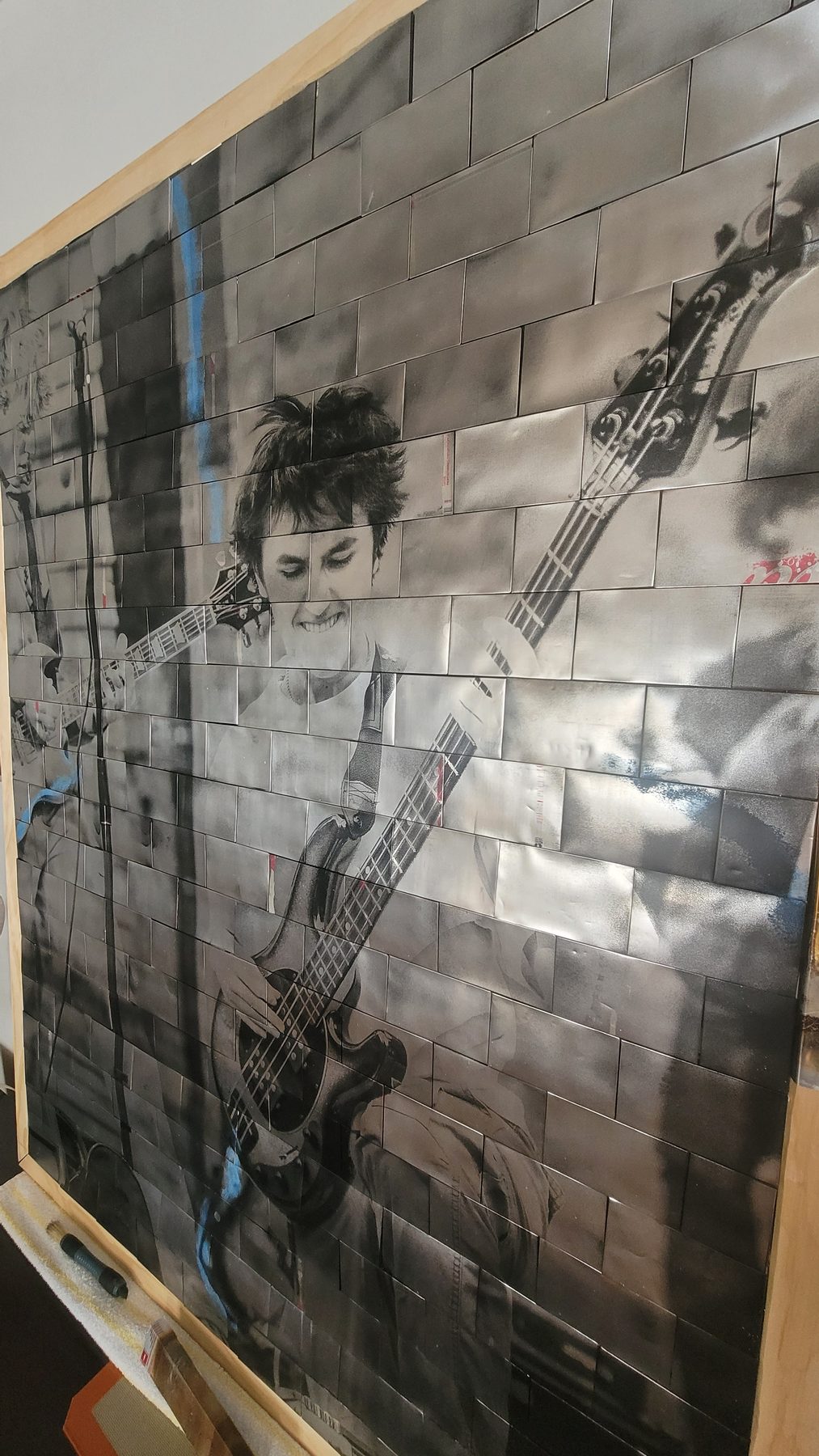 Finished reclaimed aluminum mosaic artwork displayed on a wall
