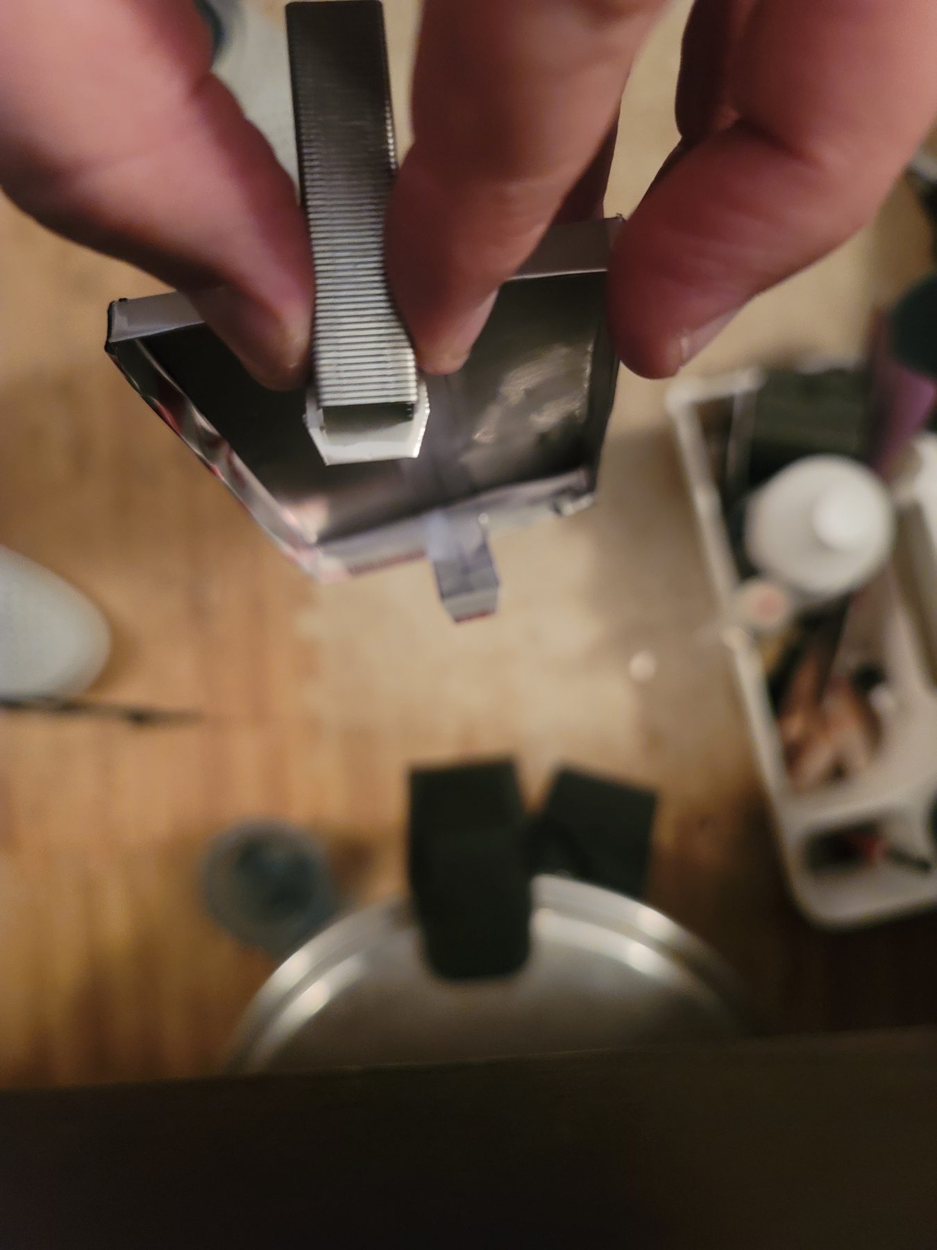 Hand cutting a small aluminum mosaic tile with a tool