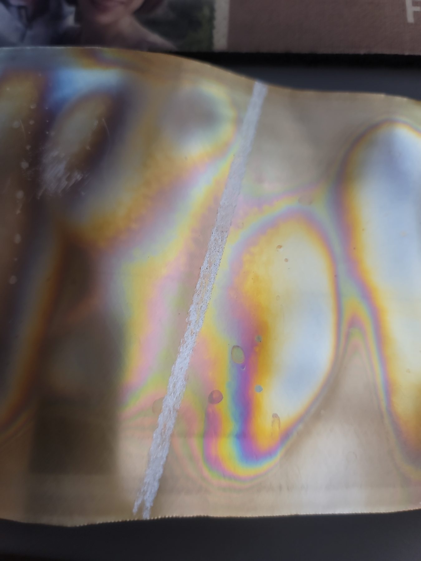 Rainbow highlight detail on a reflective aluminum mosaic surface